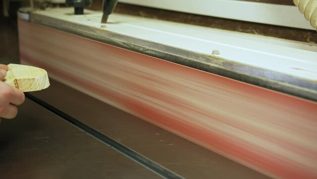 carpenter griding a heart shaped wooden piece by using a grinding machine in a workshop. High quality 4k footage