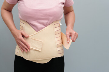 woman wearing lumbar support belts. pregnant and postnatal lumbar brace