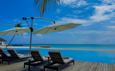 Chairs  as Umbrella In Palm Beach near poolside in the tropical blue background