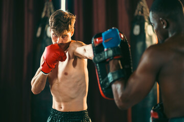 Fight fitness training of boxing in sport gym with personal trainer and sparring pads. Health motivation and muscle exercise, boxer throwing a punch, and workout with sports gloves in MMA studio.