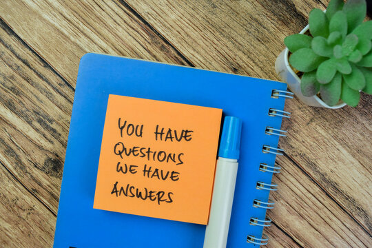 Concept of You Have Questions We Have Answers write on sticky notes isolated on Wooden Table.