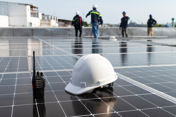 Solar installation concept White helmet blueprint and walkie talkie on solar panel High security wearing helmet at work site installing solar panels on the roof