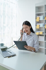 Consultant, Asian businesswoman working on the phone who discussion financial work and marketing business plan to increase company profits, ready to use computer and marketing planning documents