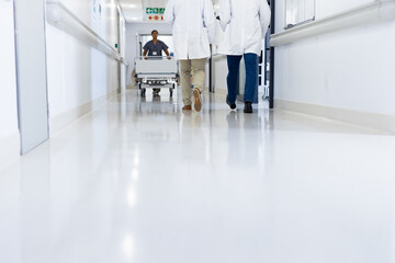 Low section of diverse doctors and medical worker in busy hospital corridor, copy space
