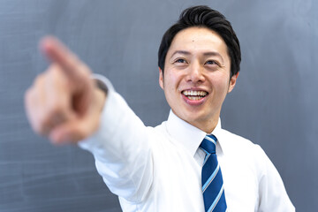 黒板を指さしをする男性の先生