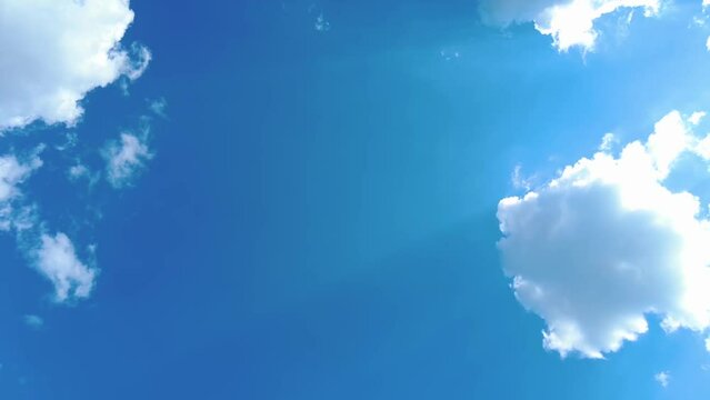 Sky time lapse clouds and blue sunny sky, Loop of white clouds over blue sky with sun Rays, Aerial view, drone shooting clouds motion time, nature blue sky a white clear weather. 4K.