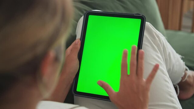 Girl Clicks Green Screen. Hand Holds Vertical Ipad Close Up. Finger Taps Center Tablet. View Web Store Site. One Touch Chroma Key Pad. Woman Poke Display. Person Work Home Room Lie Sofa. Social Media.