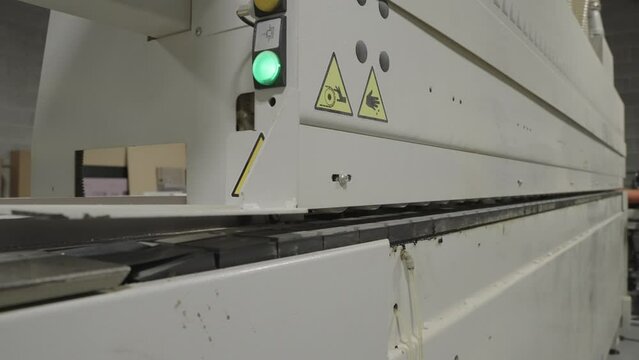 Close up, industrial mass production through feed shaper and sander