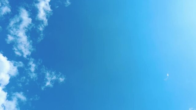 Sky time lapse clouds and blue sunny sky, Loop of white clouds over blue sky with sun Rays, Aerial view, drone shooting clouds motion time, nature blue sky a white clear weather. 4K.