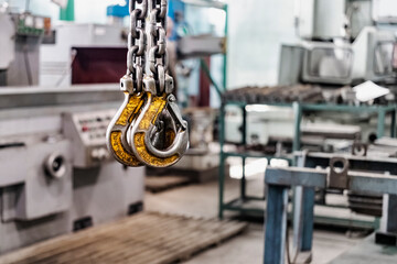 Metal industrial chains with hooks in the workshop of a metallurgical plant. Close-up. Lifting hooks for lifting heavy materials and equipment.