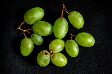 Fresh green grapes picked from the tree on a black background