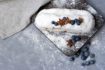 Christstollen, traditional winter holiday German bakery, stollen with raisins, decorated with blueberry and sugar powder icing, festive sweet Christmas homemade fruit cake