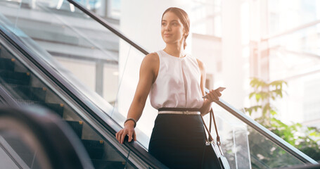 Business, thinking and woman with a smartphone, escalator and connection for social media, texting and sms. Female person, employee and agent on a moving stairway, cellphone and ideas with thoughts