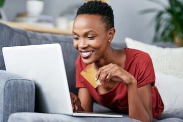 Laptop, credit card and black woman relax on a sofa for online shopping, e commerce and membership....