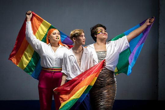 Portrait Of A Group Asian Young Gay Man Happy While Posing With Gay Pride Rainbow Flag At Studio Over Gray Background. People Lifestyle Fashion Lgbtq Concept