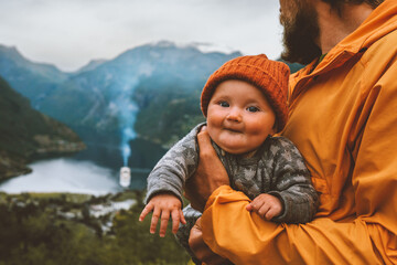 Baby with father family traveling in Norway together sightseeing Geiranger fjord infant tourist...