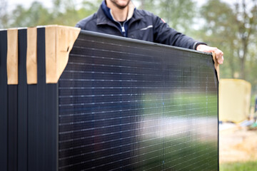 Person holding a set of several new solar panels