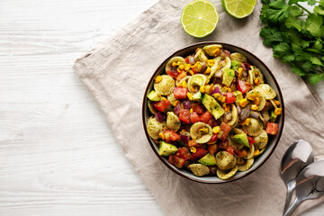 Homemade Grilled Corn Summer Pasta Salad in a Bowl on a white wooden background, top view. Flat lay, overhead, from above.