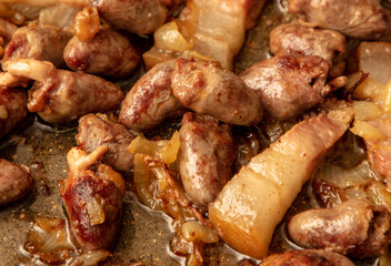 Chicken hearts are fried in a pan in oil