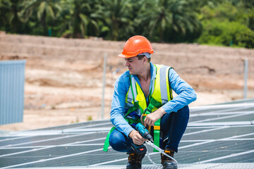 Male professional engineer installing solar photovoltaic panel system, Electrician mounting blue solar module technology on power industrial factory roof, Alternative energy ecological technician job