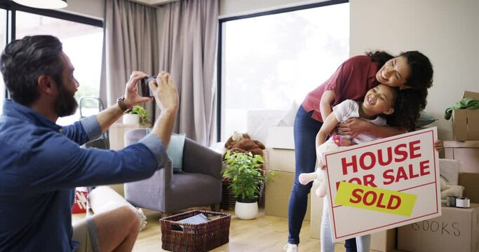 Family, phone and taking picture with sold sign in new home after moving in together. Real estate, photo and happy man, woman and kid with sale signage, laughing at funny joke and bonding in property