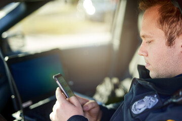 Police, officer and man texting with phone in patrol car for security contact, law enforcement...