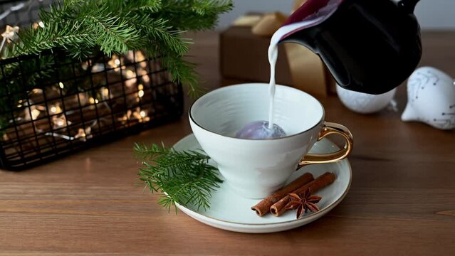 Hot milk is poured into a cup with chocolate