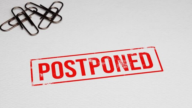 Postponed grunge rubber stamp putting on white paper with paper pins in the background. 4k 3D animation
