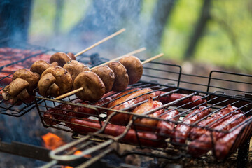 BBQ in the garden. Grilling sausages on barbecue grill.  Bavarian sausages. Barbecue cooking. Cooking food on an open fire.