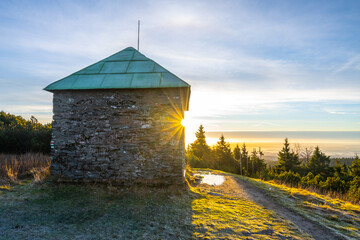 A frosty sunny morning with sun rays shining through a stone tourist shelter at Jeleni studanka in the Hruby Jesenik mountains, Czech Republic