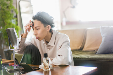 若い日本人男性のライフスタイル/リビングでメイクをしている