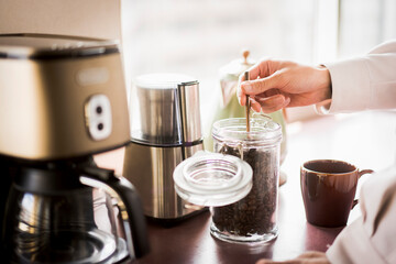 朝、キッチンでコーヒーを作っている20代の日本人の一人暮らしの男性
