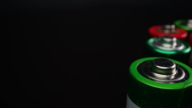 Close-up of old alkaline batteries, commonly used in toys and small appliances. Shot in macro against a dark background.