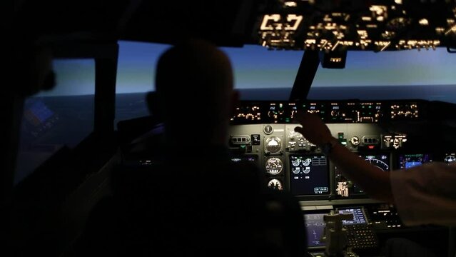 Airplane flight simulation. Aircraft cabin. Two pilots in the cockpit. Aircraft control during training. The concept of training pilots to fly an aircraft.
