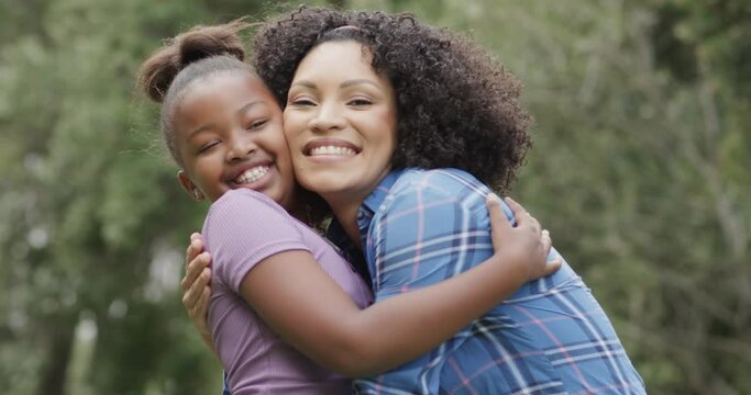 Portrait of happy diverse mother with daughter embracing in slow motion