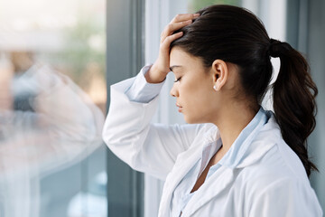 Stress, sad doctor and woman by hospital window with worry, anxiety and tired with headache in clinic. Healthcare, mental health and stressed female worker with frustrated, depression and burnout