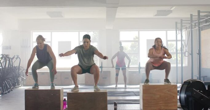 Montage of happy unaltered diverse women at gym group fitness classes, in slow motion