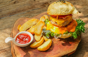 Burgers and potato chips complemented with ketchup on a wooden tray, American-style, elegant and appetizing in a vintage-style restaurant.