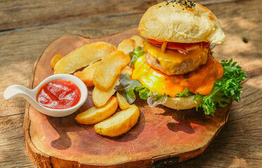 Burgers and potato chips complemented with ketchup on a wooden tray, American-style, elegant and appetizing in a vintage-style restaurant.