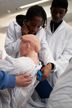 Medical students performing medical exam on dummy