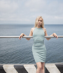 Woman in blue dress enjoys the sea in sunny day.