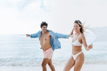Hispanic young couple in love man and woman having fun on caribbean beach in holidays or vacations...