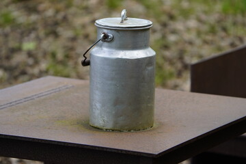 Old aluminum milk can filled with milk, as it used to be collected from the farms by the dairies for processing. District of Hanover, Germany.