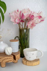 A cup of morning coffee in bed and a bouquet of tulips