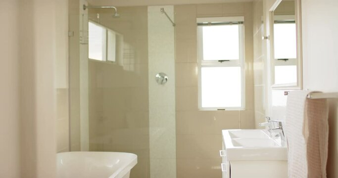 General view of modern bathroom with shower cabin, bathtub and washbasin, slow motion