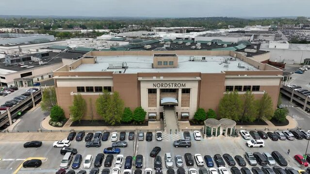 Aerial truck shot of large Nordstrom outlet attached to major shopping center. Cars navigate traffic in busy parking lot outside of trendy retail store for teens and young adults. Mall, shopping theme