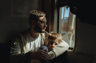 father and child sitting by the window in train. Travel concept