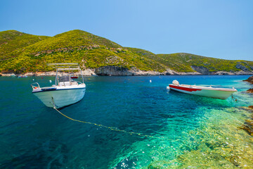 Fototapeta na wymiar Cozy little bay Porto Vromi beach with boats on the shore, turquoise Ionian sea, Zakynthos island near the blue caves