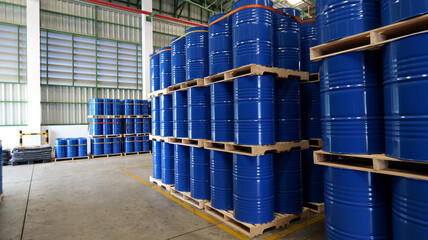 Blue barrel 200 liter chemical drums are stacked on wooden pallets inside the warehouse awaiting...