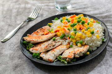 Fototapeta na wymiar Healthy sports meal, grilled chicken breast with sauteed vegetables and rice on gray background 14